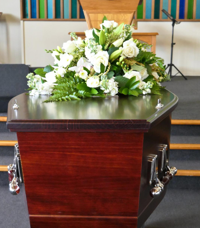 Cercueil avec composition florale lors d’une cérémonie organisée par les Pompes funèbres Audrey & Fabrice